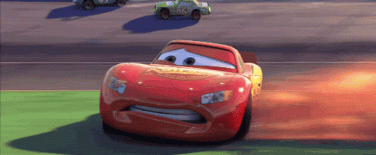 Lightning McQueen drifting sideways around a racetrack turn.